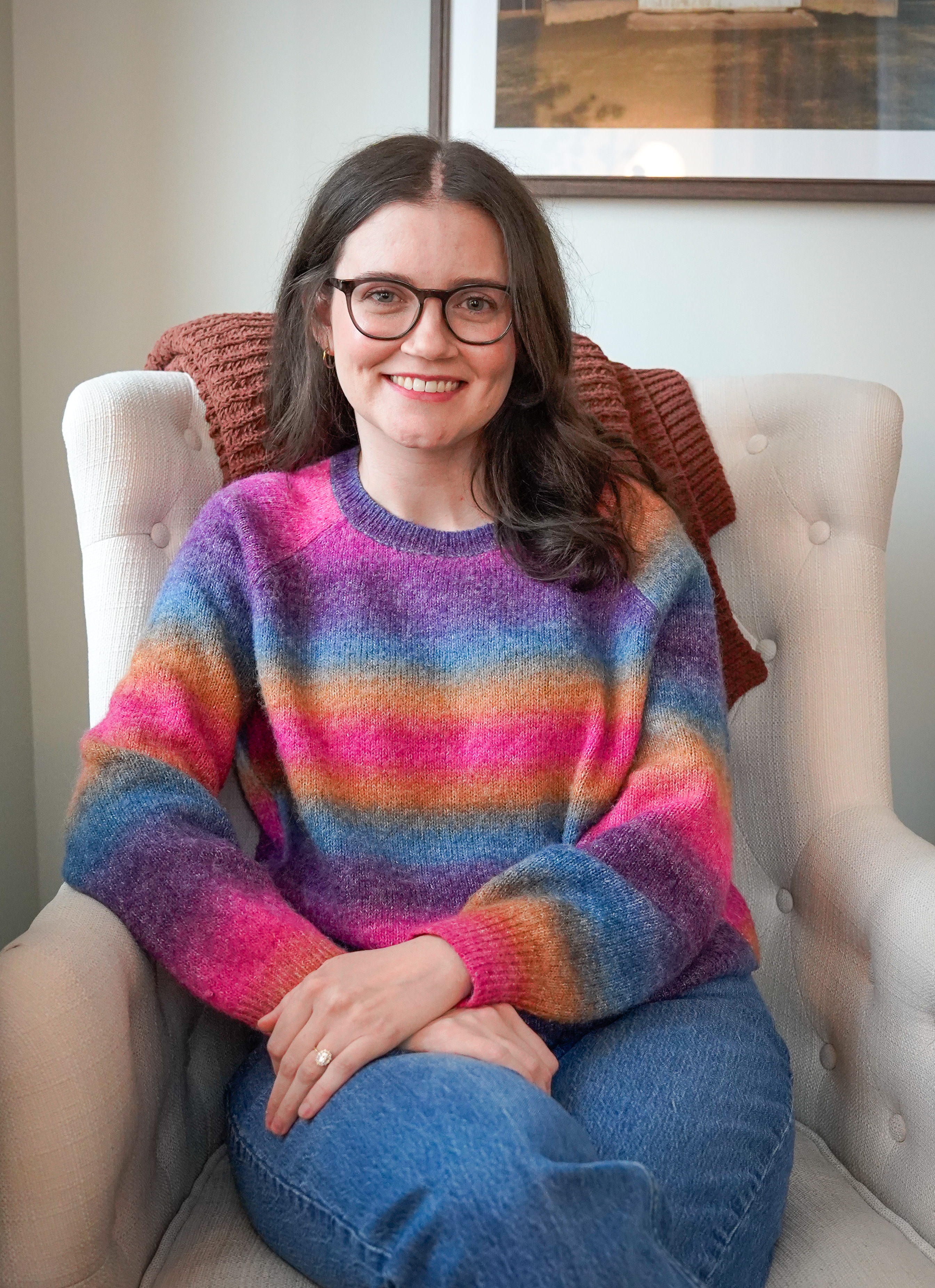 headshot of lauren wearing pink rim glasses in a green sweater